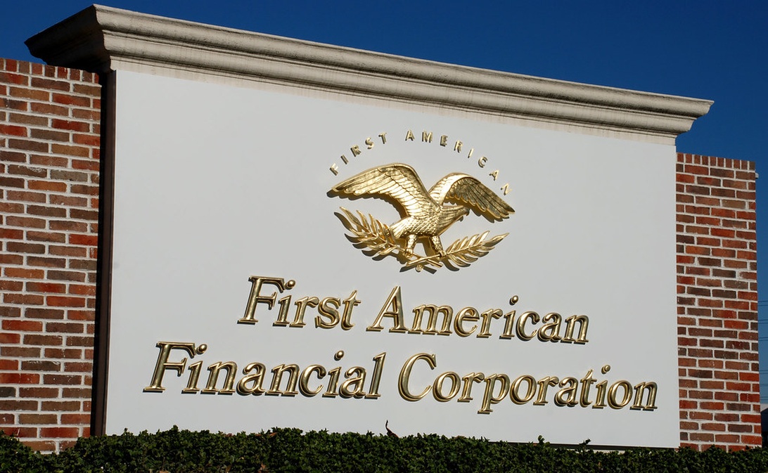 A professional sign for 'First American Financial Corporation' featuring the company name in gold lettering with an eagle emblem. The sign appears to be mounted on a brick building, representing the corporate finance sector. The clean, prestigious design suggests a well-established financial institution.